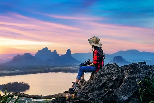Tourist sitting on a rock enjoying the sunset